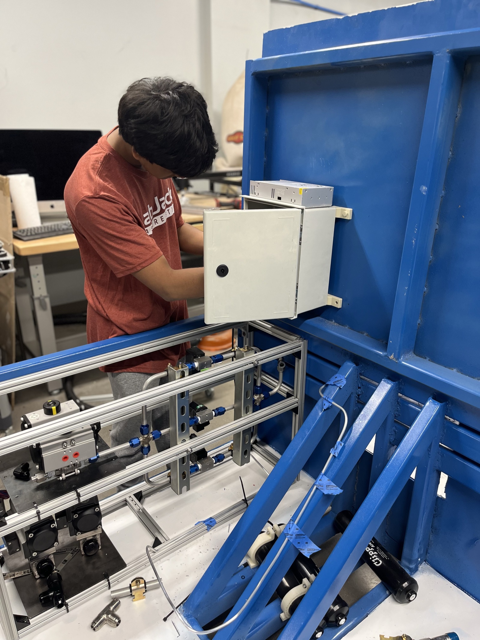 Student wiring the electronics enclosure onto the frame